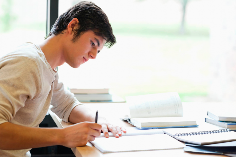 Estudante escrevendo redação para universidade no exterior.